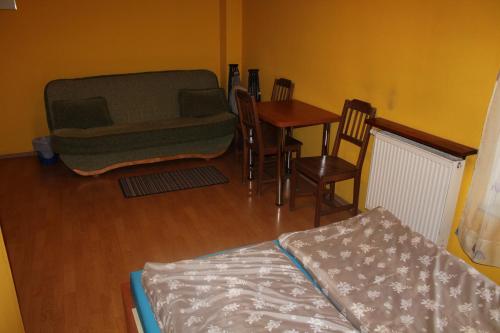 a living room with a couch and a table and chairs at Zagroda Agroturystyczna Wiecha in Mieroszów