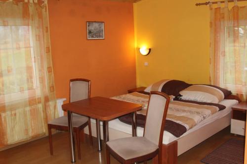 a small bedroom with a small table and a bed at Zagroda Agroturystyczna Wiecha in Mieroszów