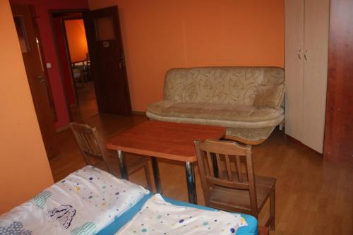 a living room with a table and a chair and a couch at Zagroda Agroturystyczna Wiecha in Mieroszów