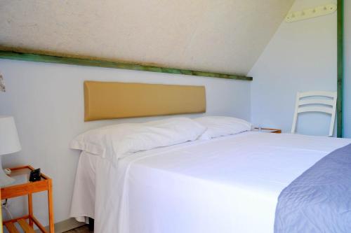 a bedroom with a white bed and a chair at Sunseabeach in Marzamemi
