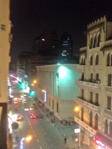 a city street at night with a building and traffic at Berlin Hotel in Cairo