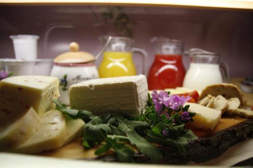 a plate of cheese and other foods with milk at Hotel La Baita in Malborghetto Valbruna