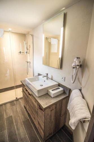 une salle de bain avec un lavabo et une douche dans l'établissement Altis Val Vert, à Brides-les-Bains