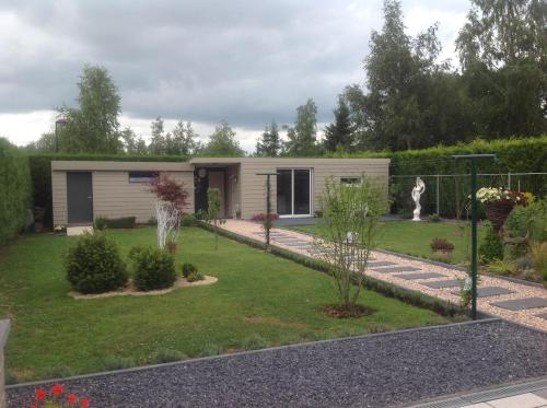 a small house in a yard with a garden at B&B Marianne in Binche