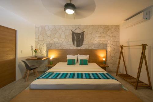 a bedroom with a bed and a stone wall at Prana Boutique Hotel Tulum in Tulum