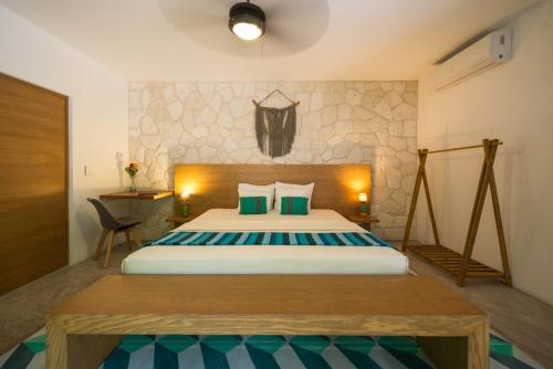 a bedroom with a large bed with green pillows at Prana Boutique Hotel Tulum in Tulum