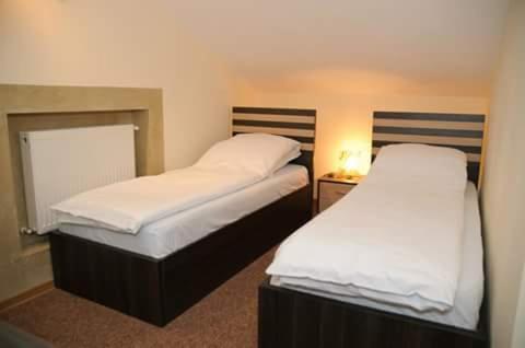two beds in a hotel room with sidx sidx sidx at Casa Onyx in Târgu Jiu