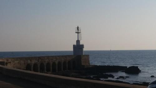 a cross on a wall next to the ocean at B&B Lilium Otranto in Otranto