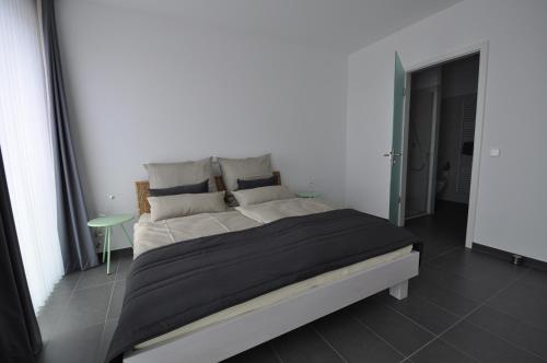 ein Schlafzimmer mit einem großen Bett in einem weißen Zimmer in der Unterkunft Apartment NewPort Bremerhaven in Bremerhaven