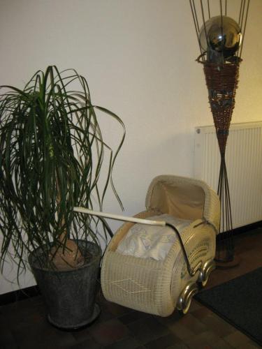 a chair and a potted plant in a room at Leuchtners an der Rennbahn in Iffezheim