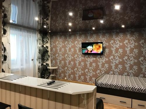 ナーベレジヌイェ・チェルヌイにあるComfortable apartmentのベッド1台と壁掛けテレビが備わる客室です。