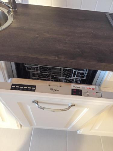 a dishwasher under a counter in a kitchen at Brenners Dorfstube in Fieberbrunn