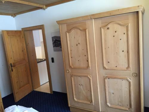 a room with a wooden cabinet and two doors at Brenners Dorfstube in Fieberbrunn