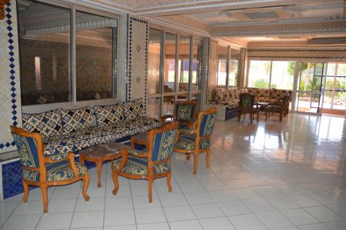 a living room with a couch and chairs and tables at Residence Yasmina Agadir in Agadir
