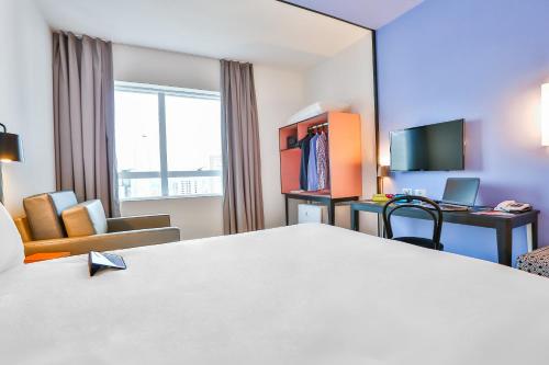 a hotel room with a bed and a desk at ibis Styles Goiania Marista in Goiânia