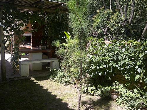 un jardín con un banco y algunas plantas en Abbá Departamentos, en Mina Clavero