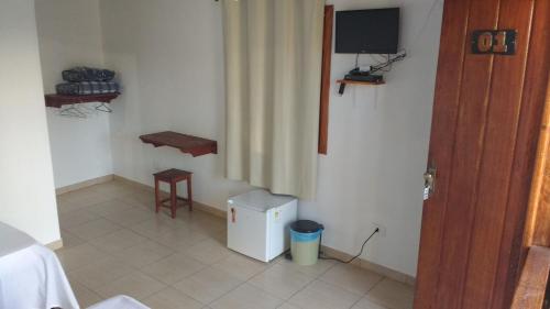 Habitación con TV y mesa. en Pousada Recanto das pedras, en São Gonçalo do Rio das Pedras