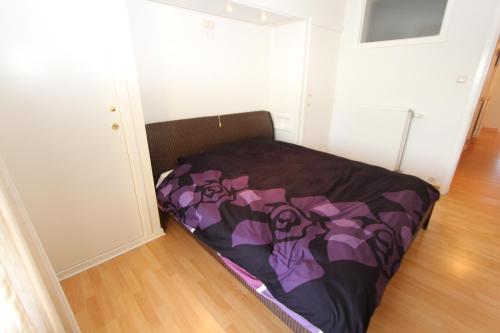 un piccolo letto in una stanza con un copriletto sopra di Zeedijk Mariakerke a Ostenda