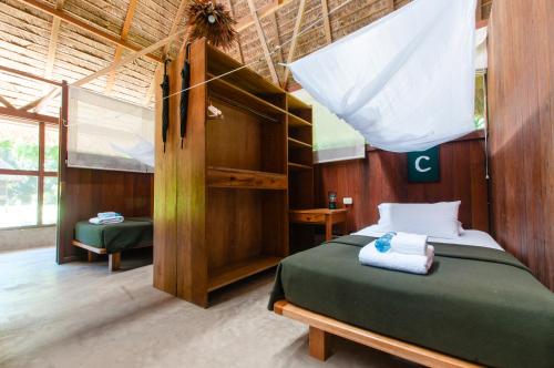 um quarto com uma cama num quarto em Amazon Field Station byInkaterra em Puerto Maldonado