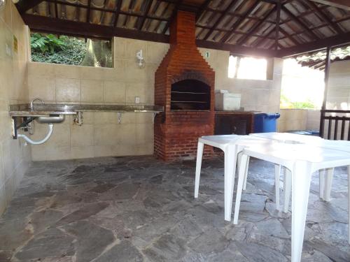 a kitchen with two white tables and a brick oven at Parque da Tijuca in Rio de Janeiro