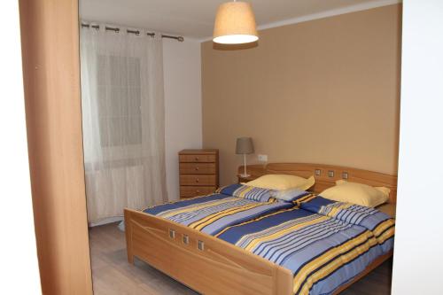 a bedroom with a bed with a blue and yellow striped sheets at Au coeur de l'Alsace in Eschau