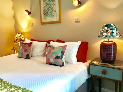 a bedroom with a bed with pillows and a lamp at Vine Valley Inn in Cessnock