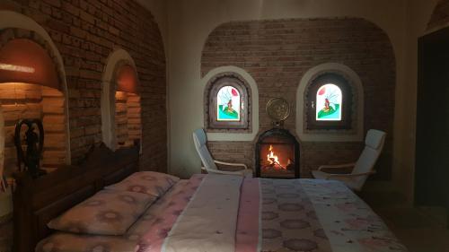 サパンジャにあるSapanca Atlı Köşk Konaklamaのテーブルと椅子、暖炉が備わる客室です。