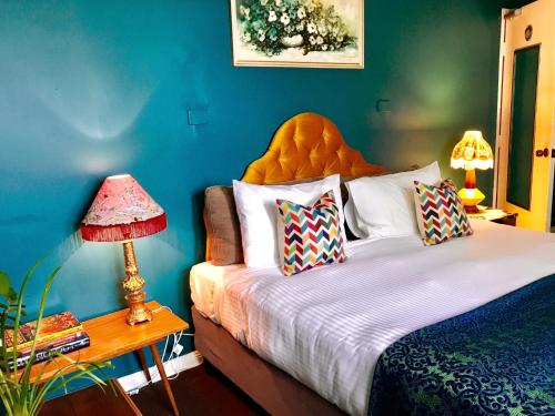 a bedroom with a bed and a blue wall at Vine Valley Inn in Cessnock