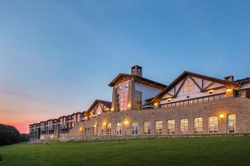 a large brick building with lights on it at dusk at Lied Lodge at Arbor Day Farm in Nebraska City