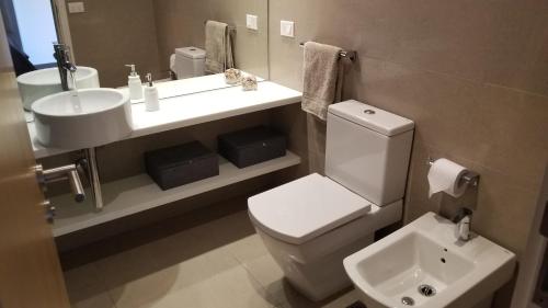 a bathroom with a white toilet and a sink at Alexander Collection in Punta del Este