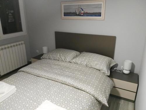 a bedroom with a bed and a picture on the wall at Apartmani Janjic in Banja Luka