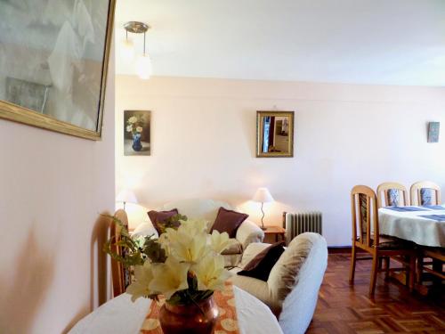 - un salon avec un canapé et une table fleurie dans l'établissement Departamento en Miraflores, à La Paz