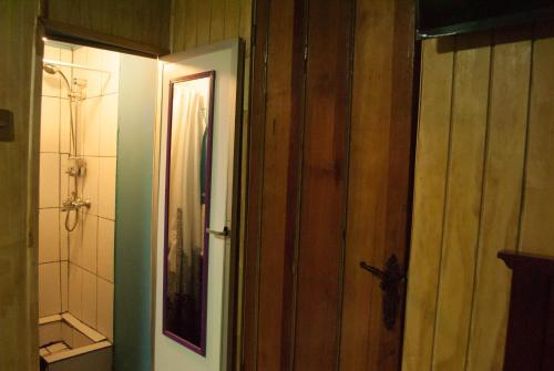 uma casa de banho com uma porta de madeira e uma casa de banho com um chuveiro em Hostel 1760 em Talca