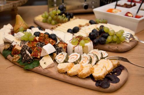 a plate of food with cheese and grapes on a table at Boutique-Hotel "Stilvoll" in Andernach