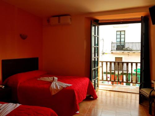 1 dormitorio con 2 camas y puerta a un balcón en Hotel Plaza Centro Historico en Veracruz