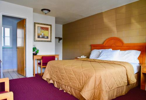 a bedroom with a bed and a table and a desk at Travel Inn Redding in Redding