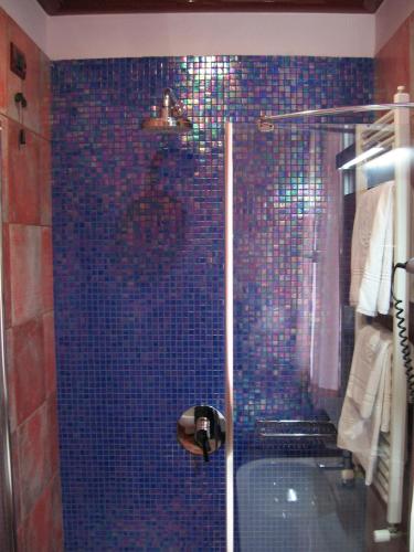a bathroom with a blue tiled shower with a tub at Hotel La Pioppa in Bologna