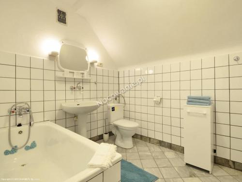 een badkamer met een bad, een toilet en een wastafel bij Apartament w Górach in Świeradów-Zdrój