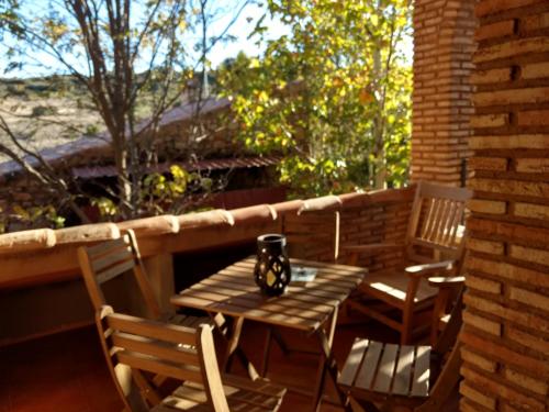 a wooden table and chairs on a porch with a table and two chairs at El Mirador De Ruidera in Ruidera