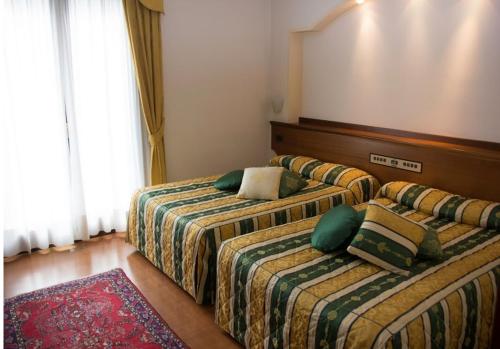 a hotel room with two beds with pillows at Hotel Piroga Padova in Selvazzano Dentro