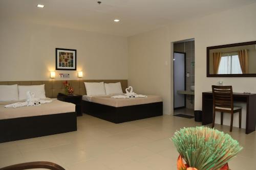 a hotel room with two beds and a table at Columbus Plaza Hotel in General Santos