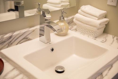 a white sink in a bathroom with towels at Midnight Sun Inn in Whitehorse