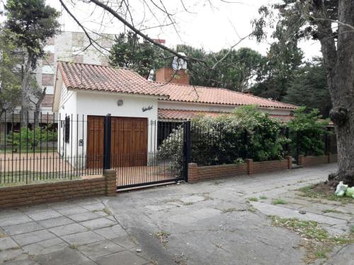 una casa con una puerta de madera y una valla en Casa Galicia en San Bernardo