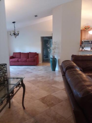 a living room with two red couches and a table at Modern Pool Home in Spring Hill
