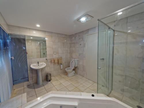 
a bathroom with a shower, sink, and toilet at 230 Scenic Drive in Bilambil Heights
