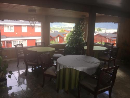 un comedor con mesas y sillas y un árbol de Navidad en Hostal Florencia en Hornopiren