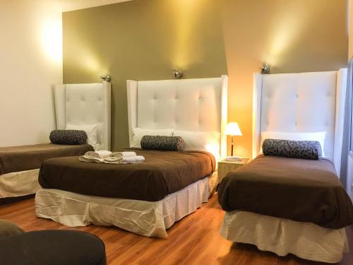 a bedroom with two beds and two windows at Galeon Mar del Plata Hotel in Mar del Plata