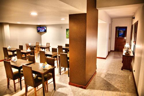 マル・デル・プラタにあるGaleon Mar del Plata Hotelの木製のテーブルと椅子のあるダイニングルーム