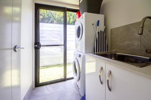 a kitchen with a sink and a refrigerator at Executive Home Accommodation 34 in Bundamba