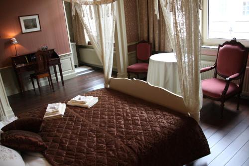 Schlafzimmer mit einem Bett, einem Tisch und Stühlen in der Unterkunft La Porte Cochère in Ypern